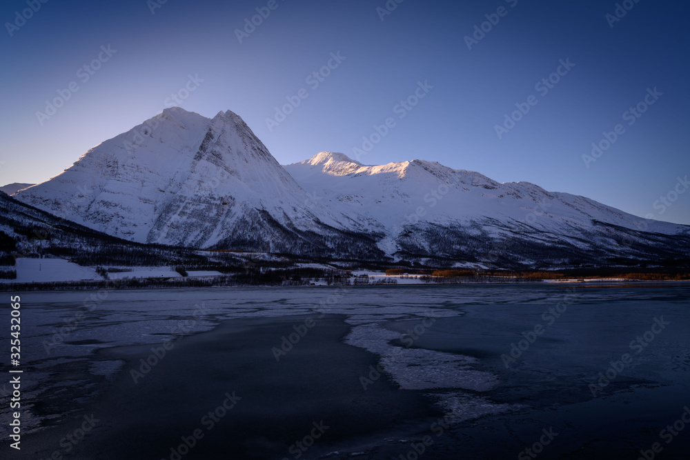 Winter Fugltinden mountain with reflection in Northern Norway