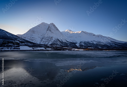 Winter Fugltinden mountain with reflection in Northern Norway