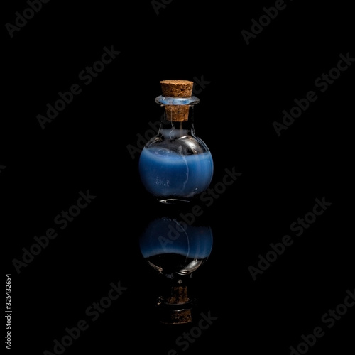 Glass test tubes with blue liquid isolated on black background.
