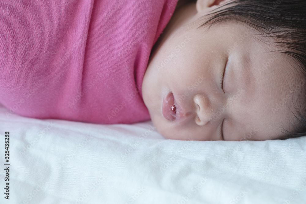 Closeup a baby sleeping comfortably on the bed Closeup a baby sleeping comfortably on the bed