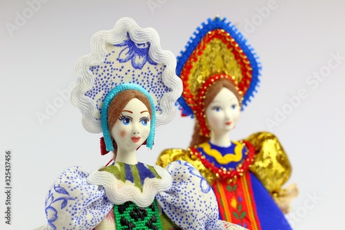 Two dolls in national Russian clothes. Sundress, kokoshnik. Light background.