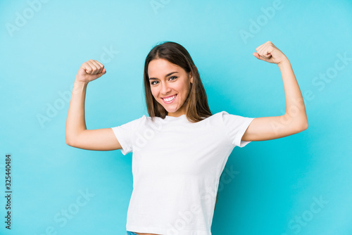 Young caucasian woman  isolated showing strength gesture with arms, symbol of feminine power