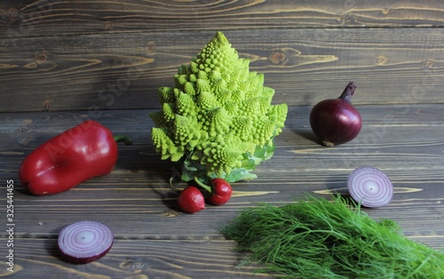 Romanesco cabbagee with pepper and onion and herbs on a brown background. photo