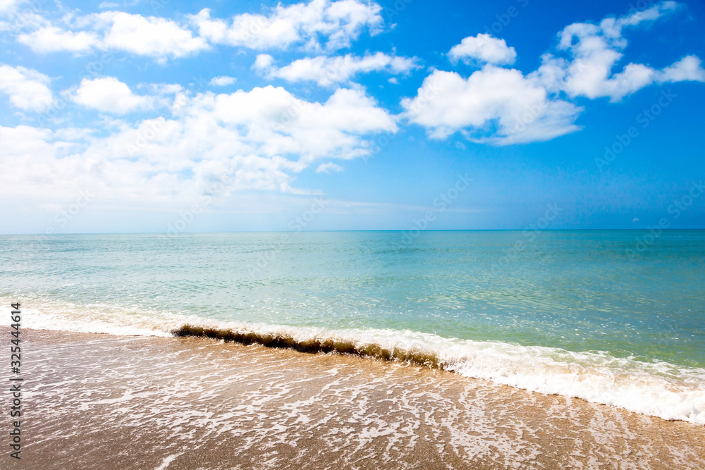 Wave on coast of Sanibel Island and blue cloudy sky Wave on coast of Sanibel Island and blue cloudy sky