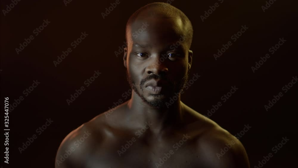 Portrait Of Young Black Man With Naked Torso In Dark Room. Portrait Of Young Black Man With Naked Torso In Dark Room.