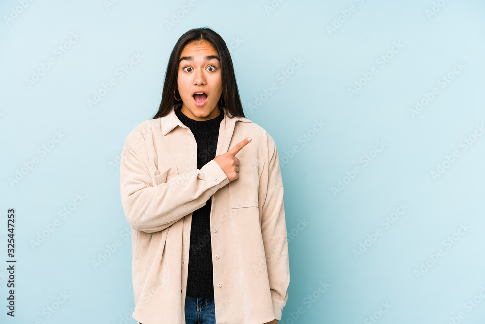 Young woman isolated on a blue background pointing to the side Young woman isolated on a blue background pointing to the side