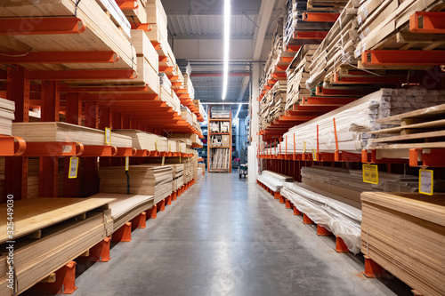 Hardware store. Shop of building materials. Racks with boards, wood and building material. loaded cart in a hardware store