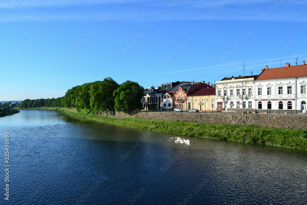 river and embankment, blue sky, white clouds, linden trees, Uzhhorod, Ukraine