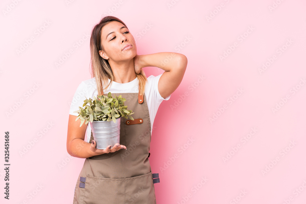 Young gardener caucasian woman isolated touching back of head, thinking and making a choice. Young gardener caucasian woman isolated touching back of head, thinking and making a choice.