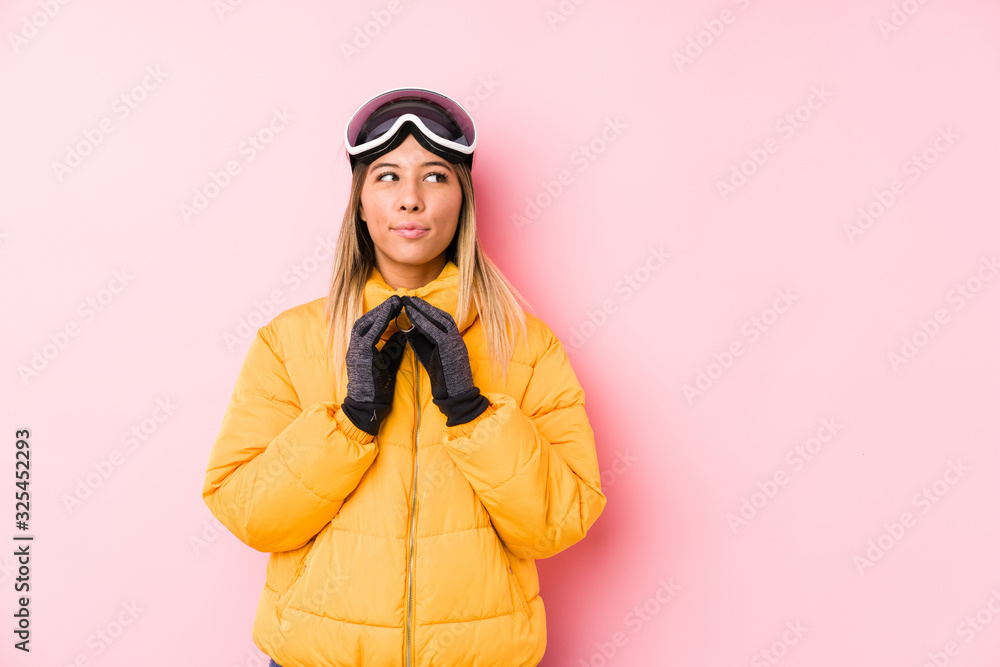 Young caucasian woman wearing a ski clothes in a pink background making up plan in mind, setting up an idea. Young caucasian woman wearing a ski clothes in a pink background making up plan in mind, setting up an idea.