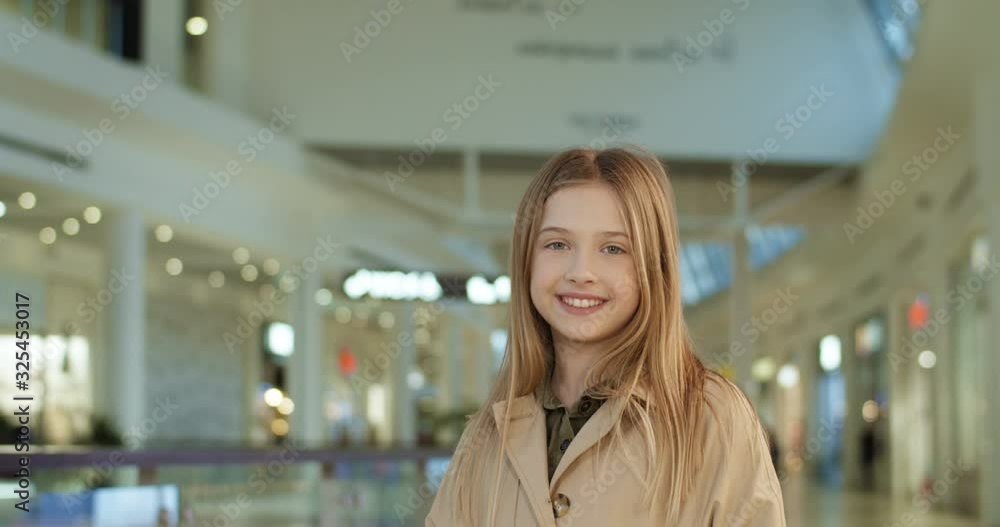 custom made wallpaper toronto digitalPortrait shot of cute Caucasian small teen girl with fair hair smiling cheerfully to camera while standing in shopping mall passage. Happy little kid looking straight with sincere smile in shop.