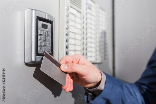 Door access control. Man hand holding key card to lock or unlock door.