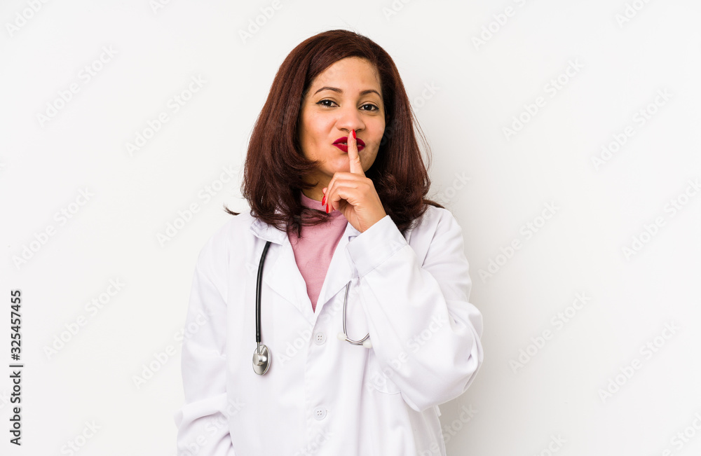 Middle age latin doctor woman isolated keeping a secret or asking for silence. Middle age latin doctor woman isolated keeping a secret or asking for silence.