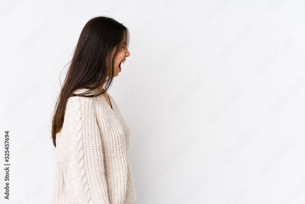 Young chinese woman isolated shouting towards a copy space