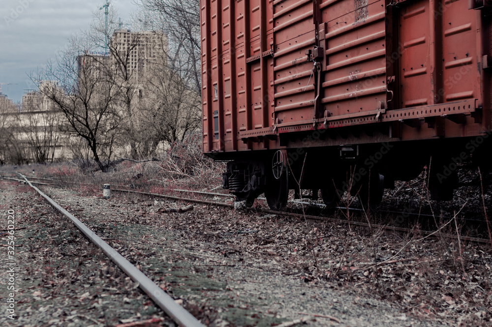 Freight car on rails. Brown wagon at an abandoned train station Freight car on rails. Brown wagon at an abandoned train station