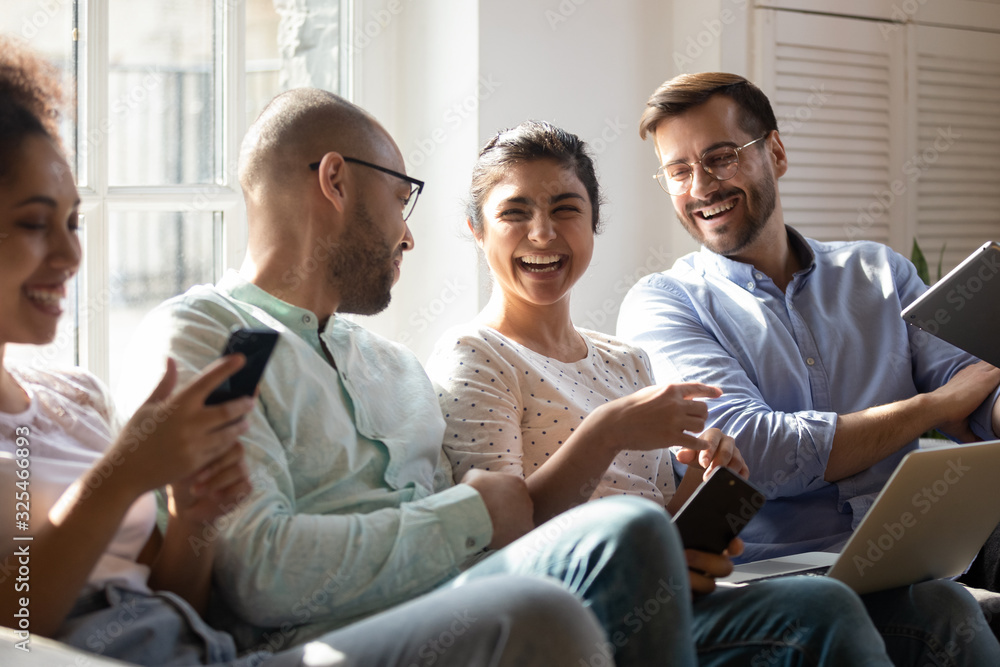 Diverse friends gathered together spend free time with modern devices Diverse friends gathered together spend free time with modern devices