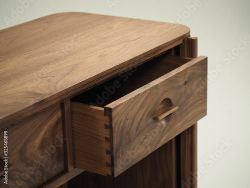 Original designer chest of drawers made of natural wood in its entirety, as well as its details on a white background, from different angles.