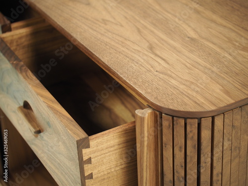 Original designer chest of drawers made of natural wood in its entirety, as well as its details on a white background, from different angles.