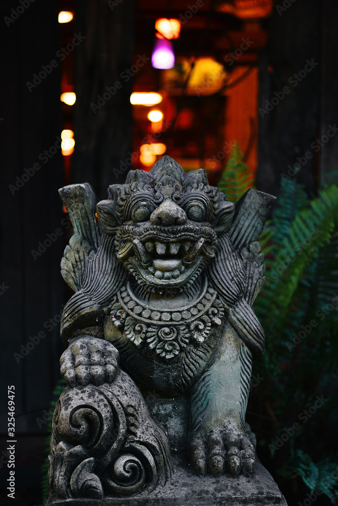 Old stone lion decorated in Bali garden Old stone lion decorated in Bali garden