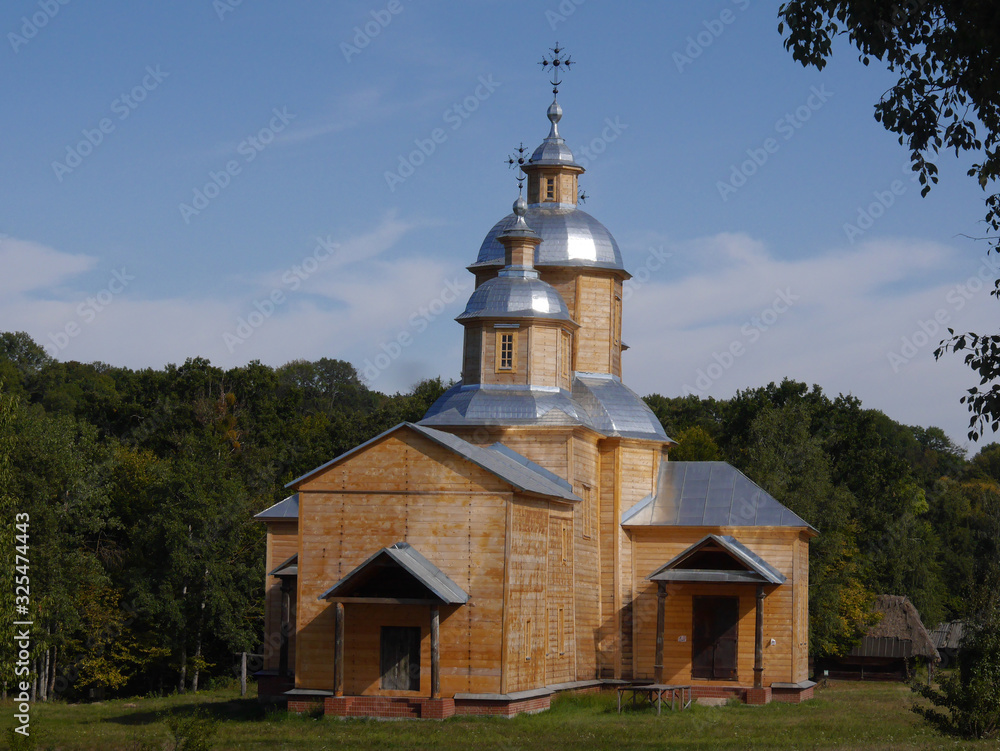 Ukrainian ancient wooden Orthodox Church. Typical rural architecture. Summer outdoor landscape. Village Pirogovo.