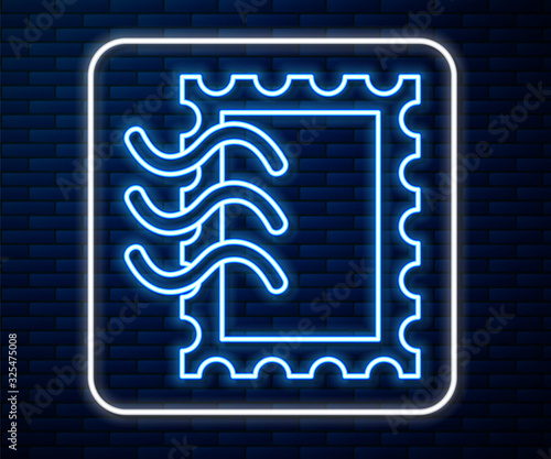 Glowing neon line Postal stamp icon isolated on brick wall background. Vector Illustration