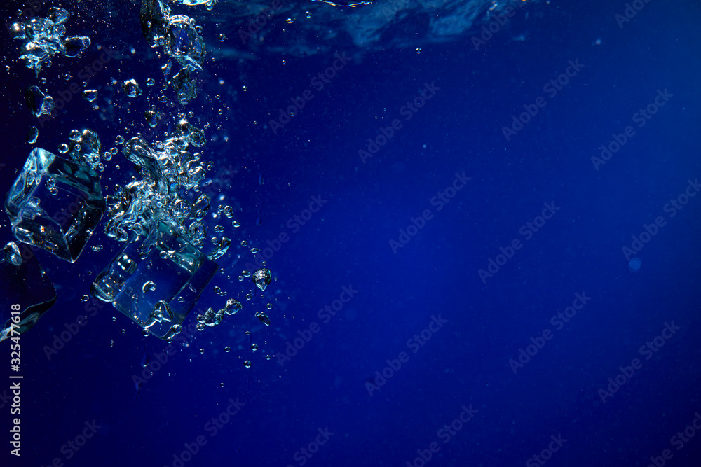 Fototapeta premium Ice cubes falling into the water