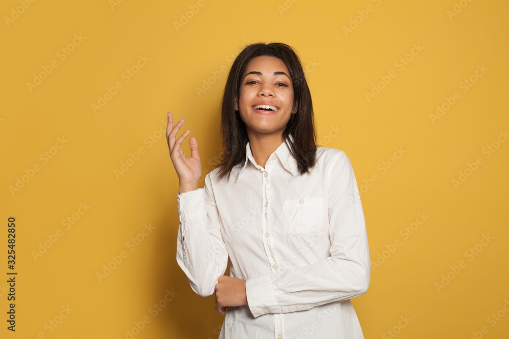 Happy black woman portrait. Beautiful young female model on yellow background Happy black woman portrait. Beautiful young female model on yellow background