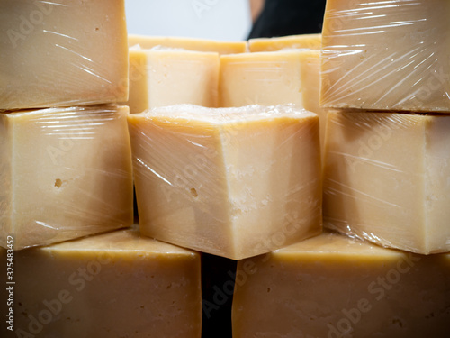 Some pieces of cheese in plastic foil on a market stand