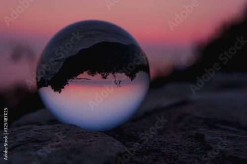 Reflejo de atardecer en una esfera de cristal
