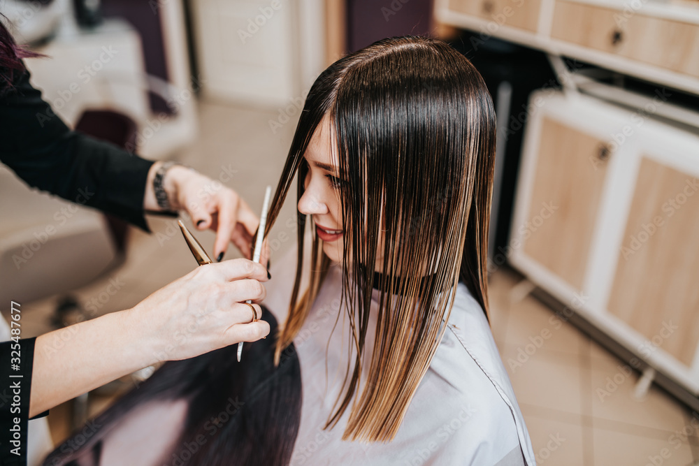 Beautiful young woman getting her haircut by a hairstylist at a beauty salon. Beautiful young woman getting her haircut by a hairstylist at a beauty salon.