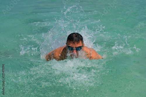 A young athletic man swimming in sea
