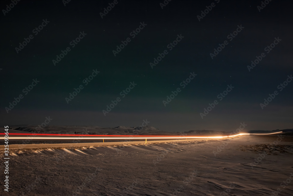 Car light trails at night on a road in Iceland