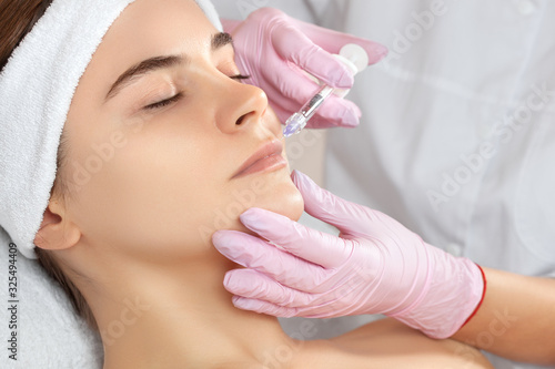 The doctor cosmetologist makes Lip augmentation procedure of a beautiful woman in a beauty salon. Prp therapy, anti wrinkle and aging skin. Cosmetology skin care.