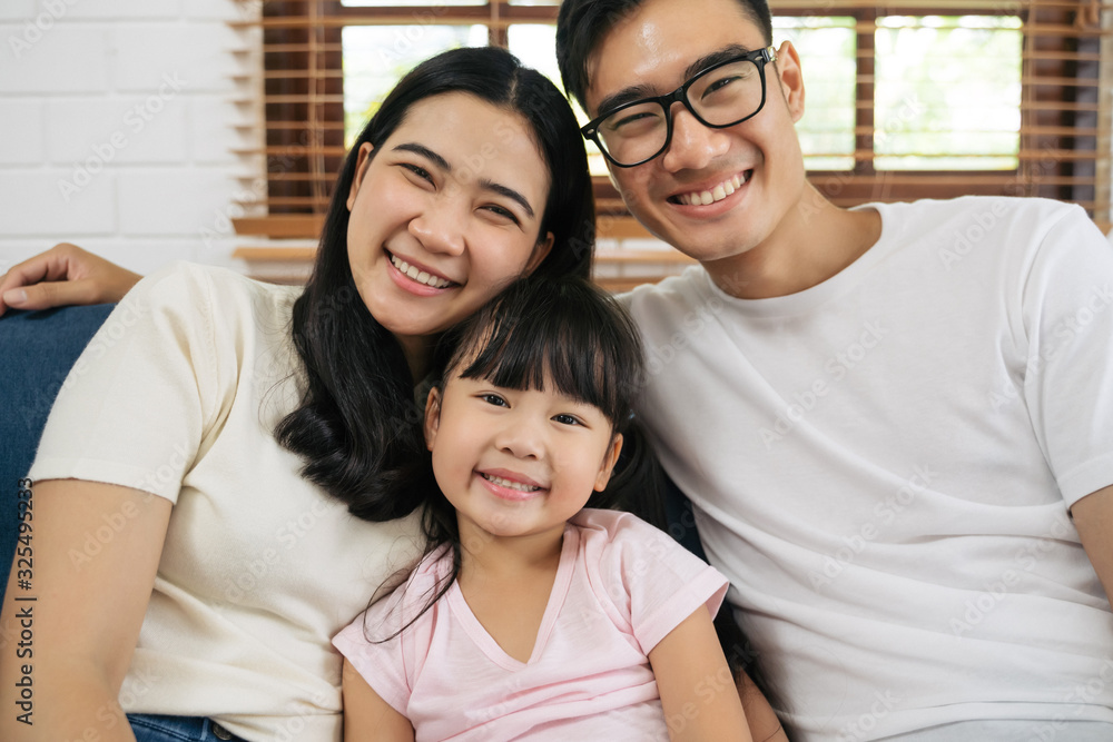 Portrait of happy Asian family spending time together on sofa in living room. family and home concept. Portrait of happy Asian family spending time together on sofa in living room. family and home concept.