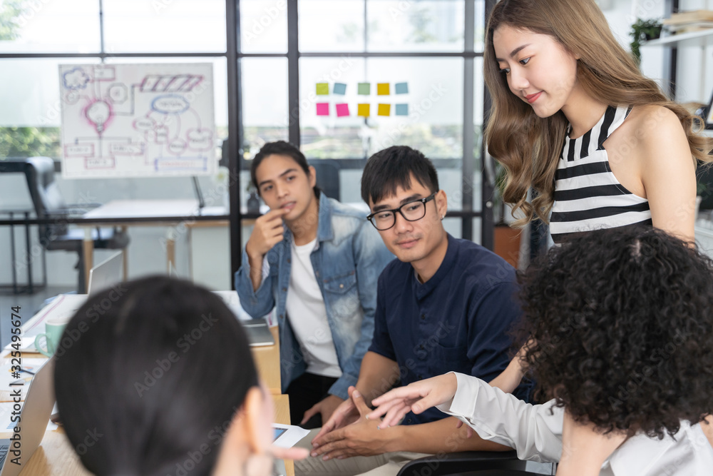 © saksit - Group of Asian business people team meeting in modern office working  planning and share ideas concept