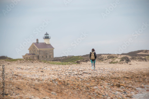 Woman walking down a stony beach in the summer