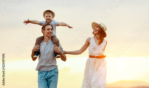 Happy family father of mother and child son  on nature at sunset. © JenkoAtaman