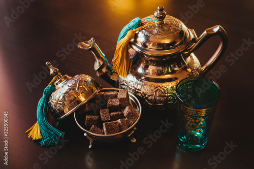 Teapot, sugar, tea glasses on a brown table