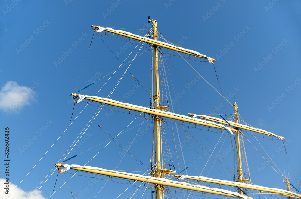 the mast of a sailboat against a blue sky. the mast of a sailboat against a blue sky.