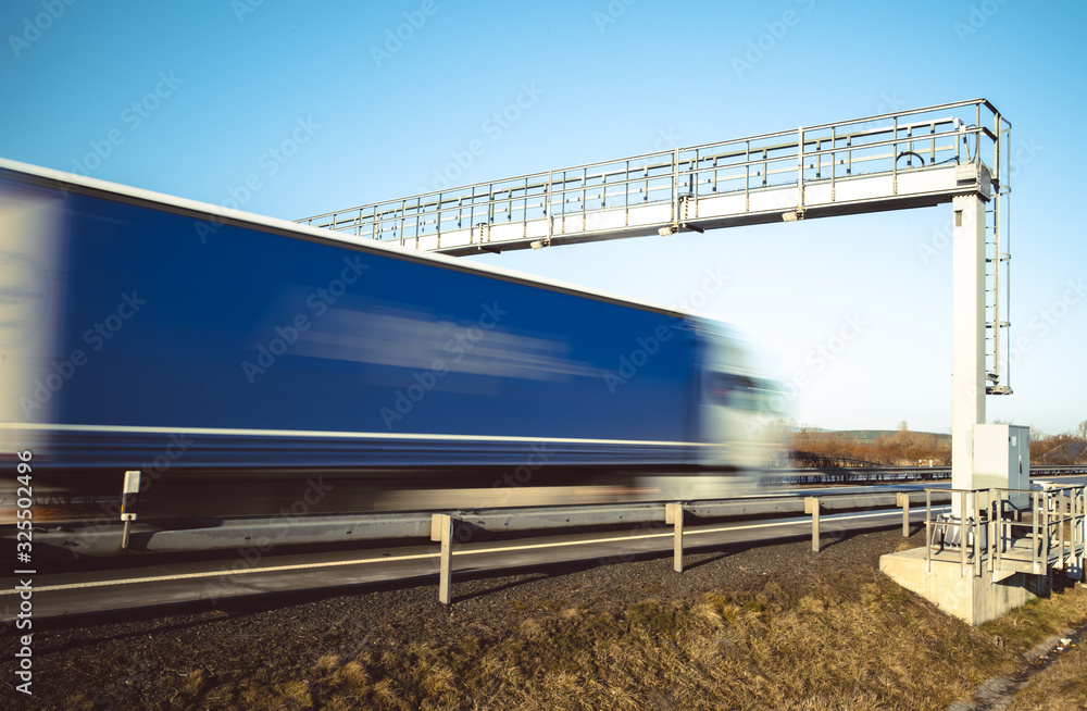 truck drive through the highway through the toll gate, toll charges, blurred motion in the image truck drive through the highway through the toll gate, toll charges, blurred motion in the image