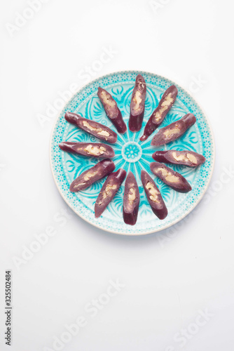 churchkhela sprinkled with icing sugar on a plate with oriental-style ornament