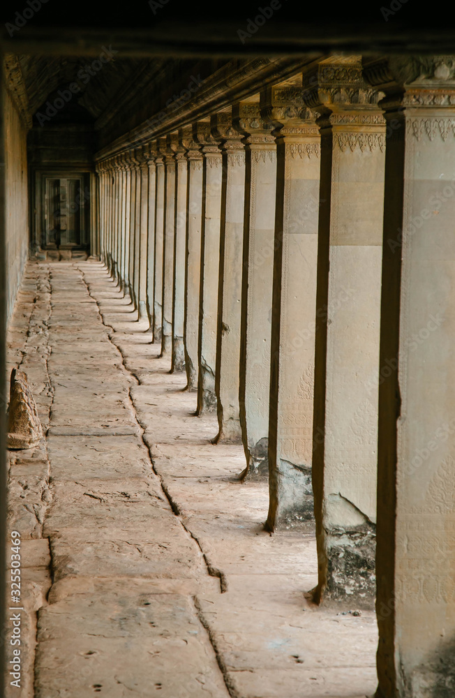 long corridor with stone columns in an ancient temple in cambodia