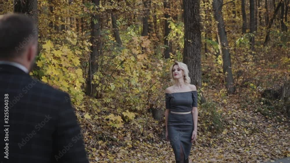 Pretty lady walks and flirts to her gentleman in autumn park Pretty lady walks and flirts to her gentleman in autumn park