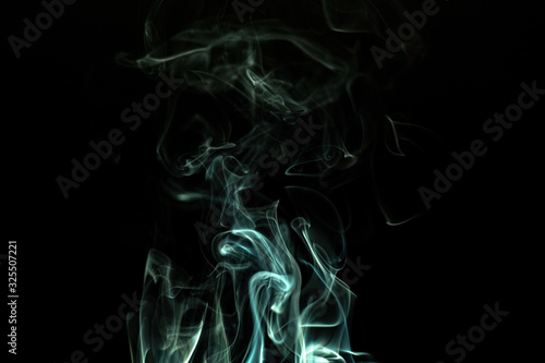 Smoke/incense rising against black background