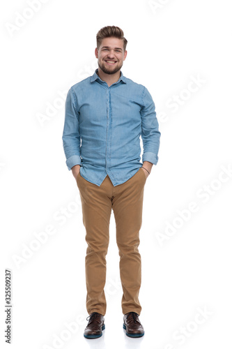 Positive casual man laughing with both hands in his pockets