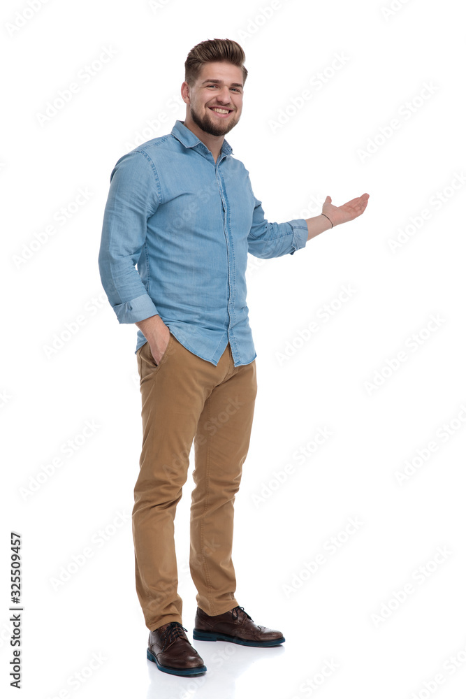 Smiling casual man presenting with his hand in his pocket Smiling casual man presenting with his hand in his pocket