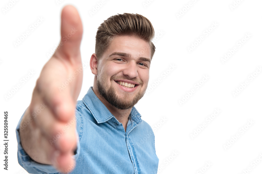 Cheerful casual man smiling and reaching for a handshake Cheerful casual man smiling and reaching for a handshake