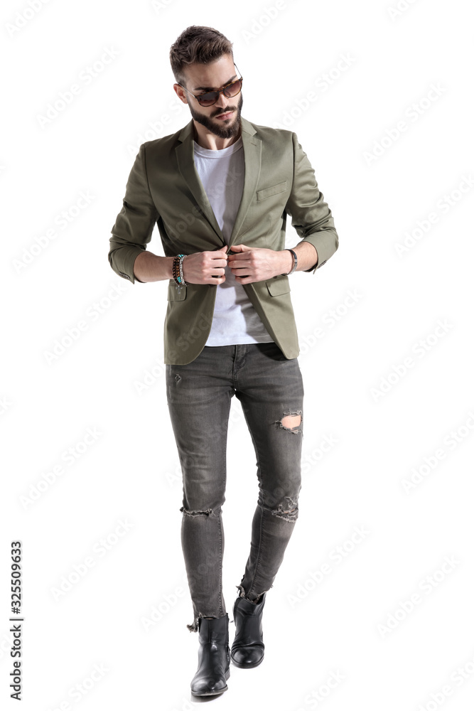 Confident fashion model unbuttoning his jacket and looking away Confident fashion model unbuttoning his jacket and looking away