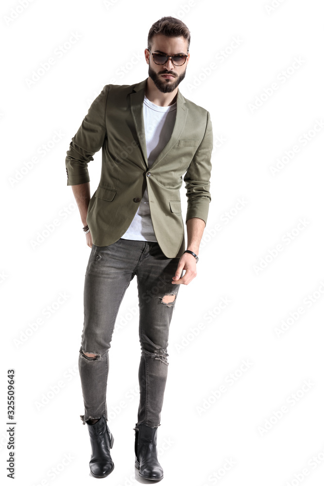 Serious model holding his hand in his back pocket Serious model holding his hand in his back pocket