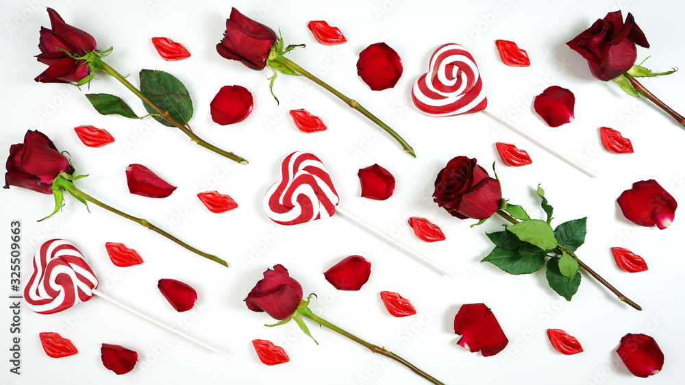 Red roses, petals, heart shaped lollipops and lip shaped chocolate kisses creative composition layout flat lay. Red roses, petals, heart shaped lollipops and lip shaped chocolate kisses creative composition layout flat lay.